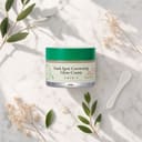 Axis-Y Dark Spot Glow Cream on surface with botanical and brightening elements