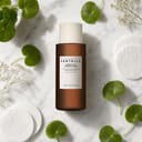 Skin1004 Probio-Cica Essence Toner on surface with cotton pads and centella