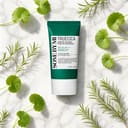 Some By Mi Truecica Suncream on surface with centella and tea tree elements